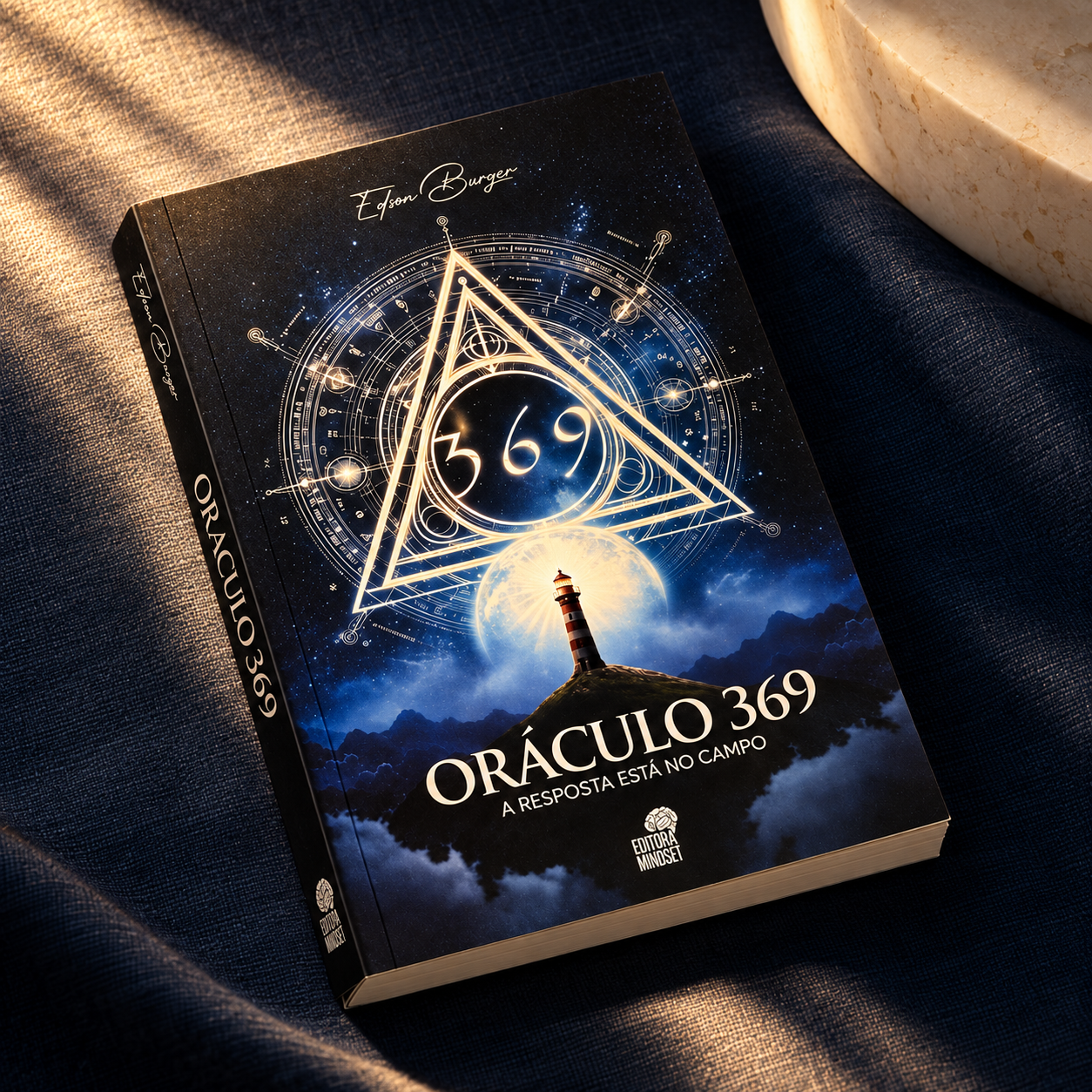 Oráculo 369 sobre tecido azul, iluminado por luz dourada.